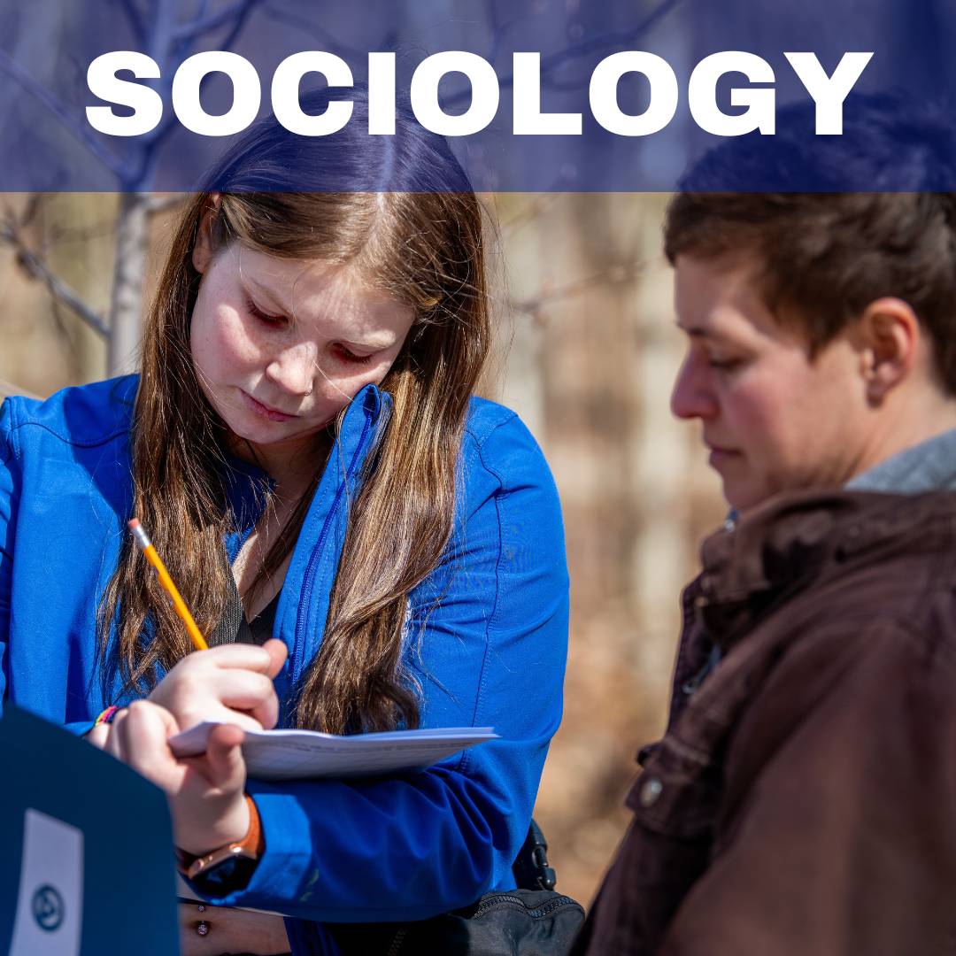 person writing on a piece of paper outside